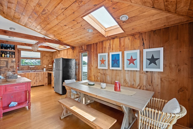 0 Burr Is, Branford, CT 06405 - dining space with vaulted ceiling with skylight, wood walls, wooden ceiling, and light wood finished floors