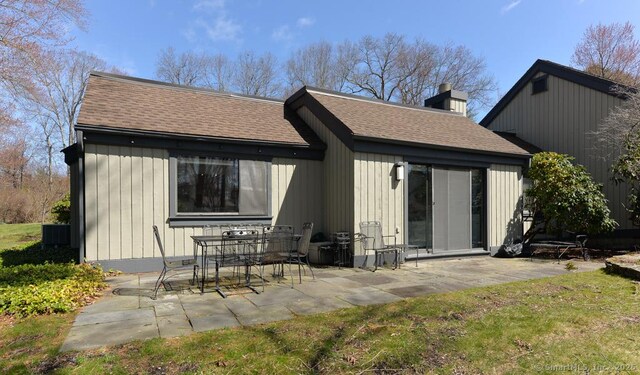 894 Heritage Vlg Unit B, Southbury, CT 06488 - back of house featuring central AC, a chimney, a patio, and roof with shingles