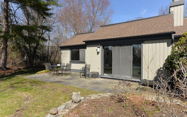894 Heritage Vlg Unit B, Southbury, CT 06488 - back of property with a patio, a chimney, a shingled roof, and a lawn