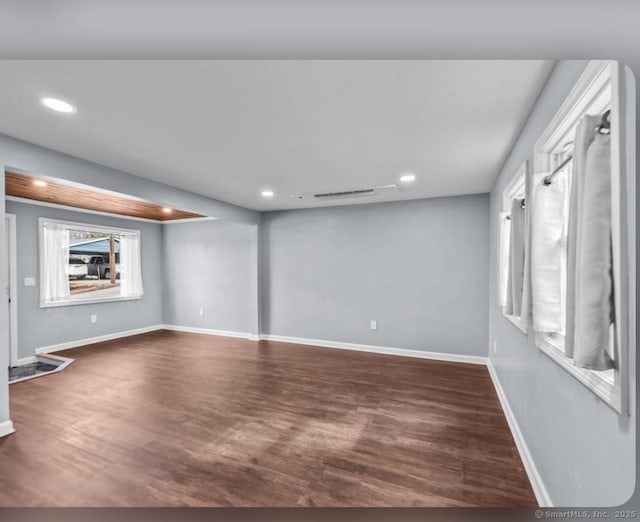basement with recessed lighting, visible vents, baseboards, and dark wood finished floors