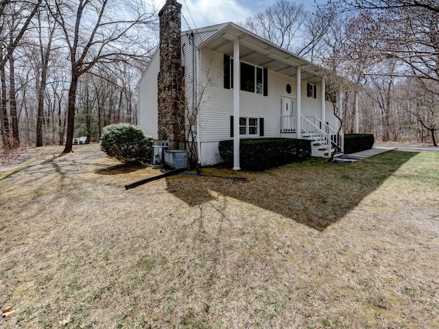 split foyer home featuring a porch, a chimney, and central AC