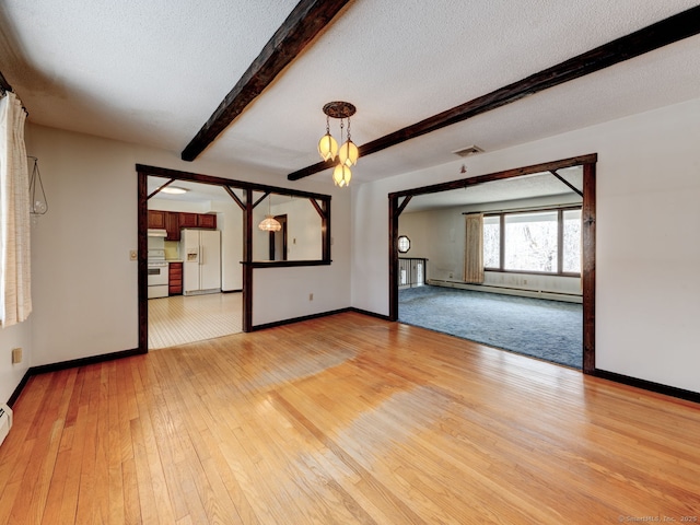 spare room featuring light wood-style flooring, beamed ceiling, a baseboard radiator, and baseboards
