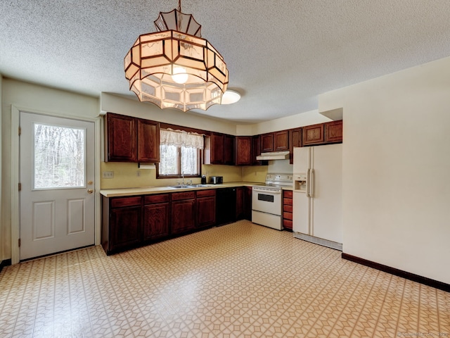 kitchen featuring white appliances, light countertops, a sink, and a textured ceiling