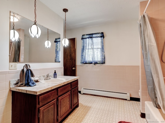 full bathroom with tile walls, wainscoting, vanity, tile patterned floors, and a baseboard heating unit