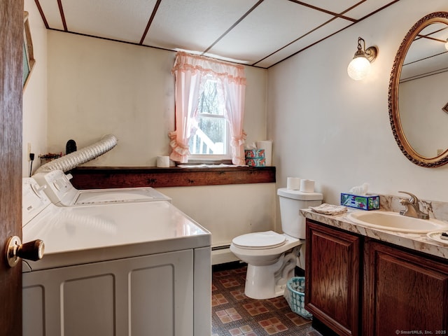 bathroom featuring vanity, toilet, washing machine and clothes dryer, a baseboard radiator, and tile patterned floors