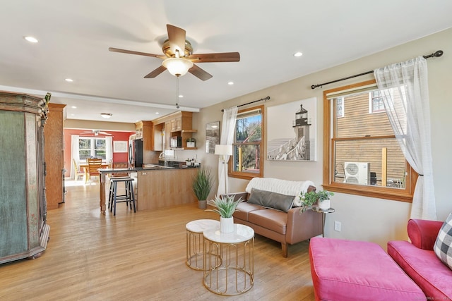 living room featuring a ceiling fan, recessed lighting, and light wood-style flooring