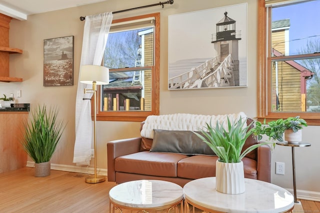 sitting room with baseboards and wood finished floors