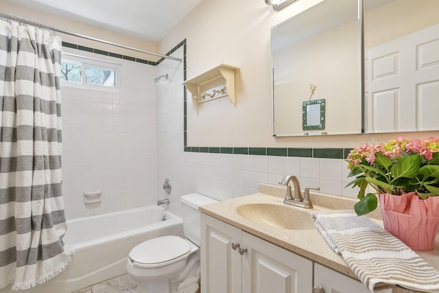 full bath featuring shower / bath combo, a wainscoted wall, toilet, tile walls, and vanity