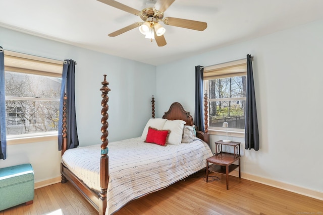 bedroom with light wood finished floors, baseboards, and ceiling fan