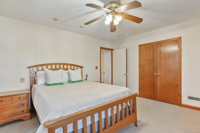 bedroom with visible vents, a ceiling fan, and light colored carpet