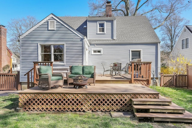 back of property featuring a gate, fence, a deck, and a shingled roof