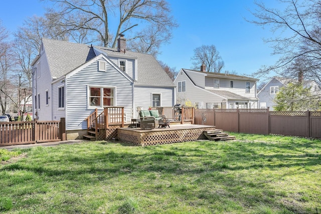 rear view of property with a chimney, a fenced backyard, a yard, a wooden deck, and roof with shingles