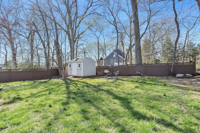 view of yard with an outbuilding, a shed, and a fenced backyard