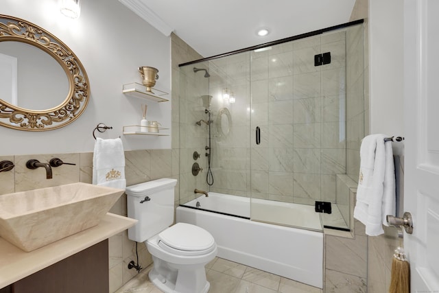 bathroom with ornamental molding, toilet, vanity, and enclosed tub / shower combo