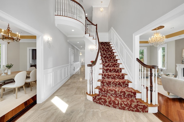 staircase featuring a decorative wall, a notable chandelier, and a healthy amount of sunlight