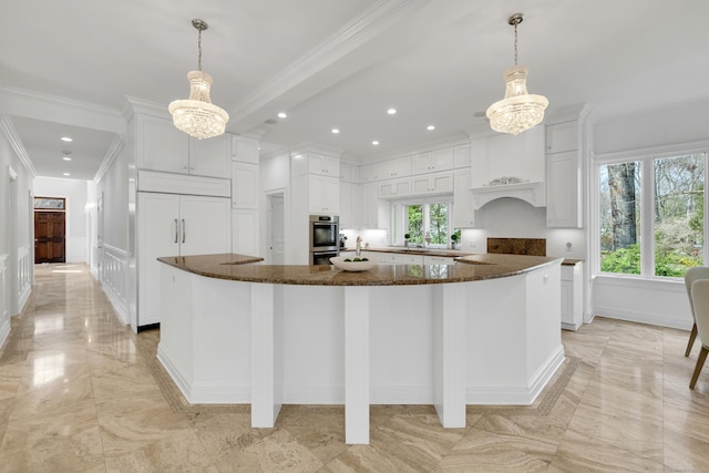 kitchen with a healthy amount of sunlight, an inviting chandelier, and white cabinets