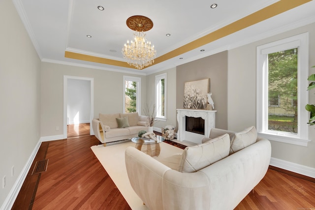 living room featuring a premium fireplace, wood finished floors, baseboards, and visible vents