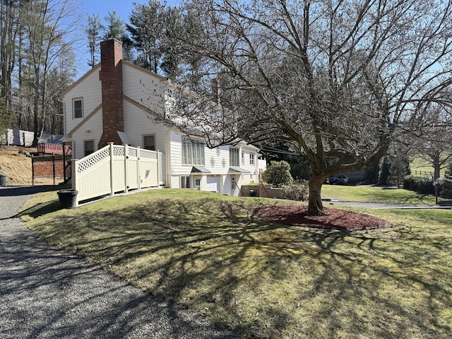 view of property exterior with a chimney and fence