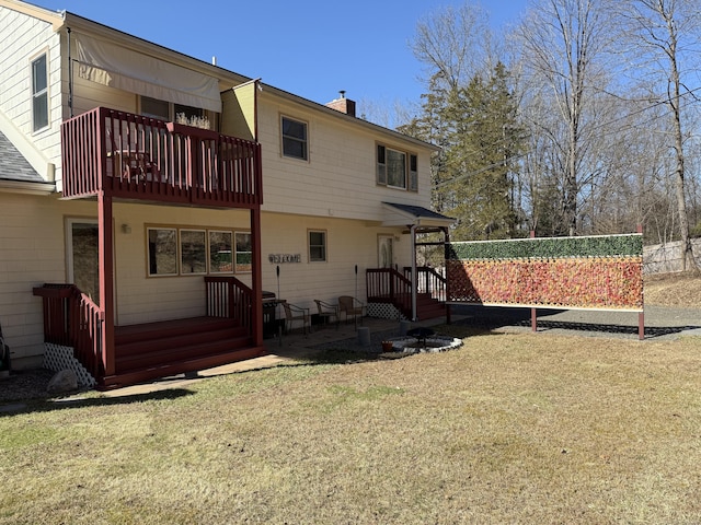 back of property with a chimney, a balcony, and a lawn