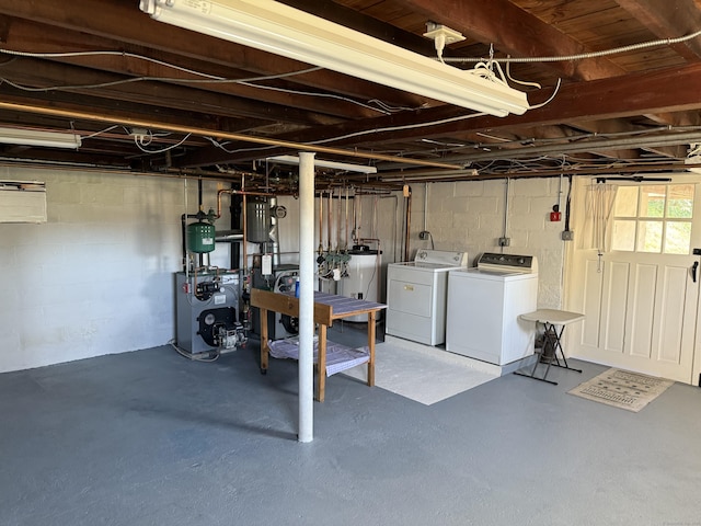 below grade area with washing machine and clothes dryer, gas water heater, and a heating unit