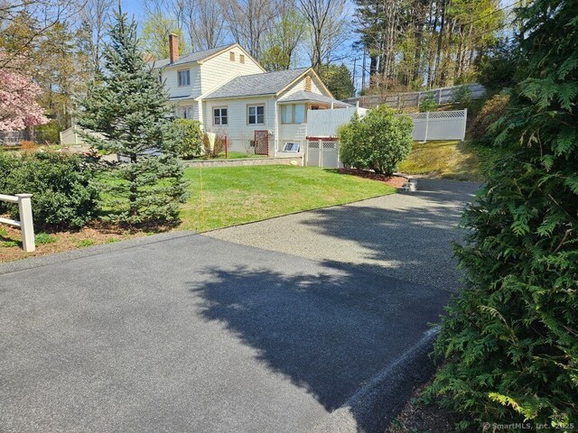 230 Old Field Rd, Southbury, CT 06488 - raised ranch featuring a chimney, a front lawn, aphalt driveway, and fence