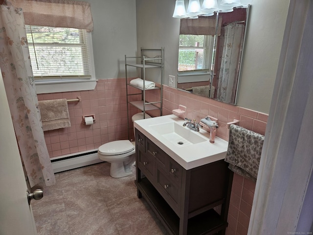 full bathroom with tile patterned flooring, toilet, vanity, tile walls, and baseboard heating