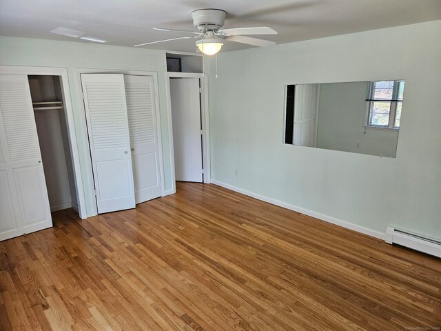 230 Old Field Rd, Southbury, CT 06488 - unfurnished bedroom with baseboard heating, multiple closets, light wood-style floors, ceiling fan, and baseboards