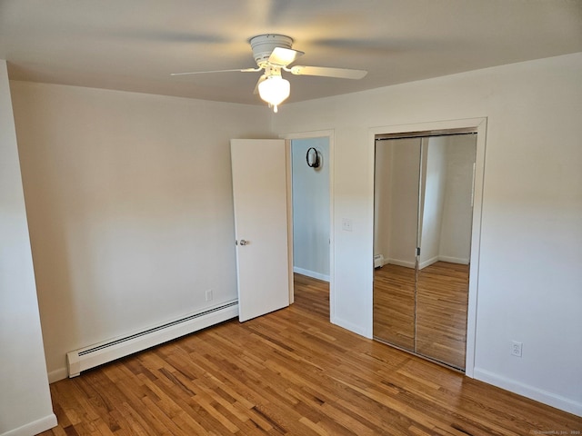 unfurnished bedroom featuring ceiling fan, wood finished floors, a closet, and a baseboard radiator