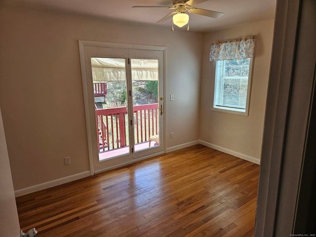 spare room featuring wood-type flooring, baseboards, and ceiling fan