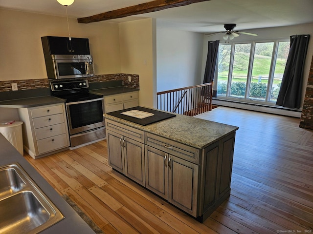 kitchen with a baseboard heating unit, light wood finished floors, backsplash, ceiling fan, and appliances with stainless steel finishes