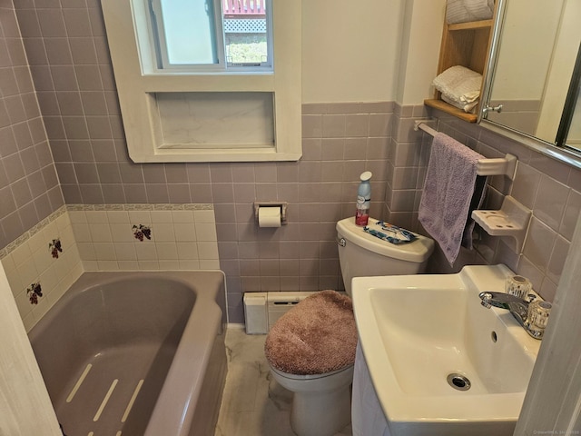 bathroom with a garden tub, toilet, a sink, and tile walls