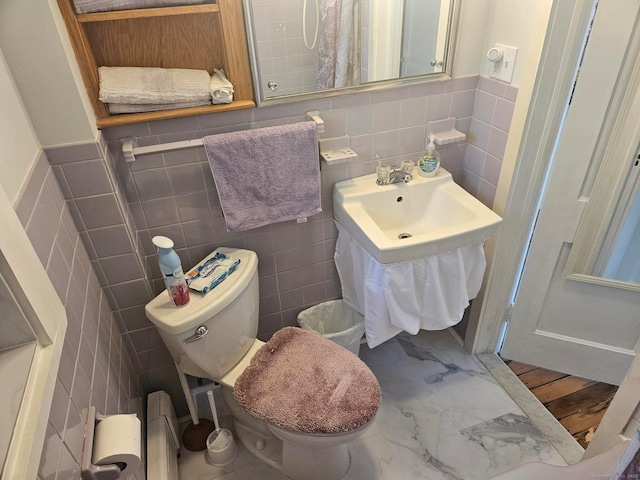 bathroom featuring marble finish floor, tile walls, and toilet