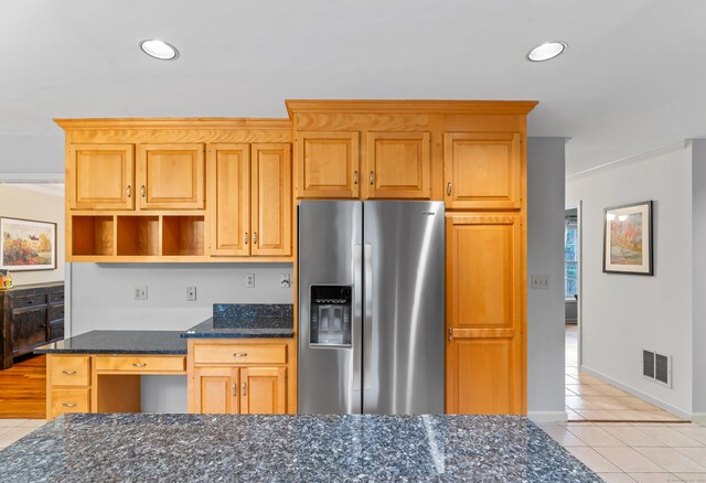 kitchen with light tile patterned floors, visible vents, open shelves, and stainless steel fridge