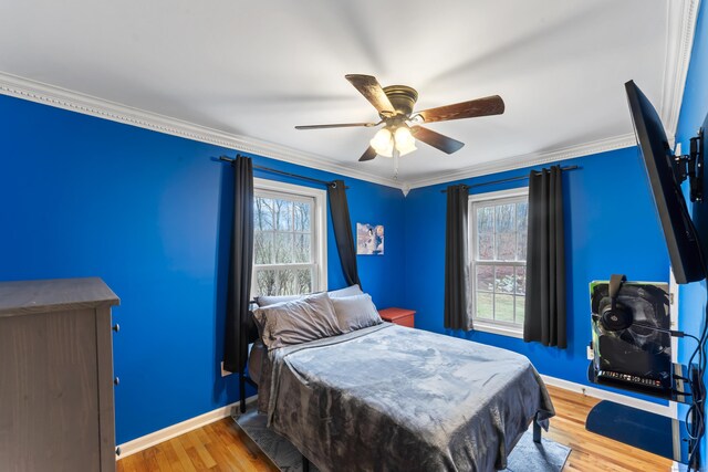 bedroom featuring ornamental molding, baseboards, a ceiling fan, and wood finished floors