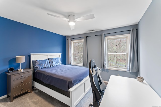 carpeted bedroom featuring visible vents, baseboards, and a ceiling fan