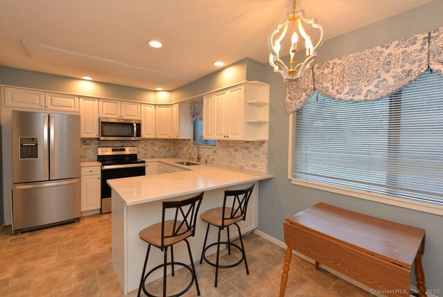 16 Heritage Vlg Unit A, Southbury, CT 06488 - kitchen featuring appliances with stainless steel finishes, tasteful backsplash, a peninsula, a chandelier, and light countertops