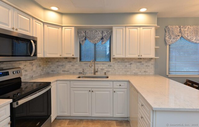 16 Heritage Vlg Unit A, Southbury, CT 06488 - kitchen with appliances with stainless steel finishes, a peninsula, white cabinets, and recessed lighting