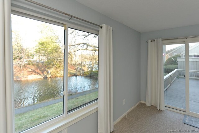 16 Heritage Vlg Unit A, Southbury, CT 06488 - carpeted empty room featuring a water view and baseboards