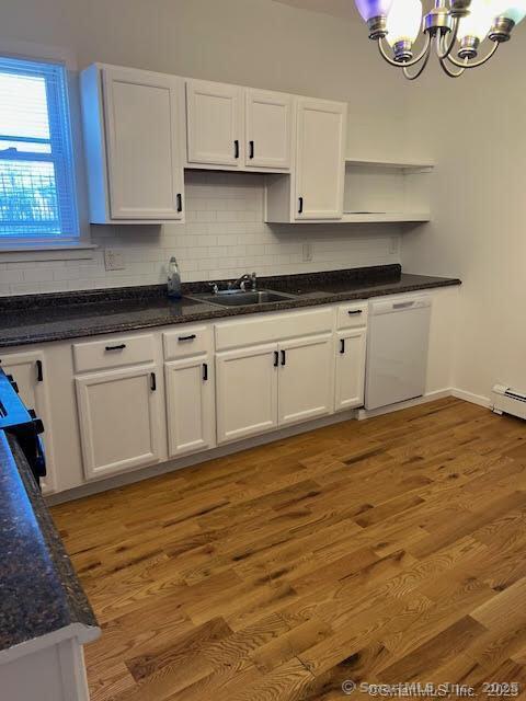 kitchen featuring a chandelier, white cabinetry, open shelves, white dishwasher, and a sink