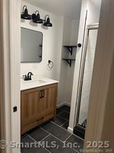 bathroom featuring tile patterned floors, vanity, and a stall shower