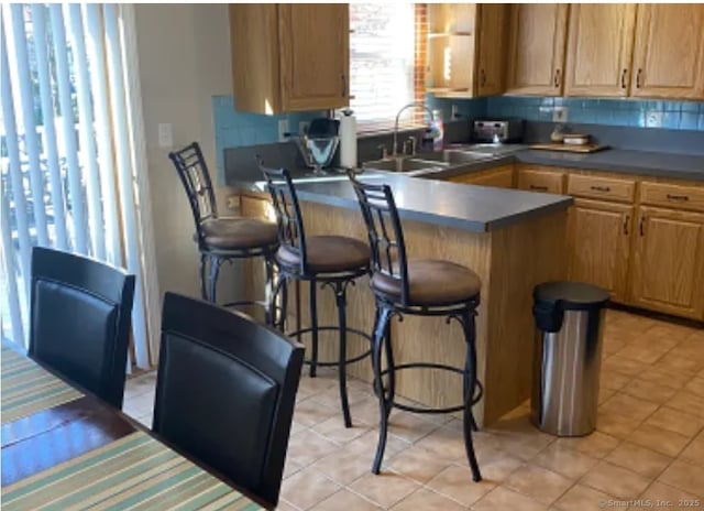 41 Wilshire Blvd, Milford, CT 06460 - kitchen with dark countertops, a sink, tasteful backsplash, and a breakfast bar