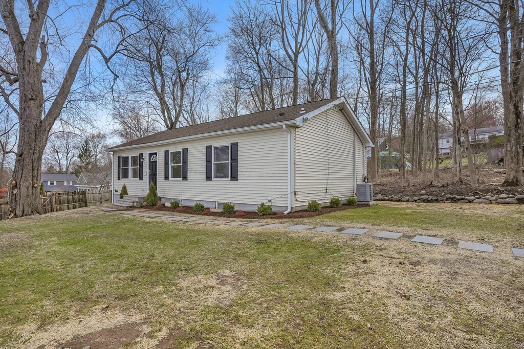 3 Nanuet Rd, New Fairfield, CT 06812 - view of front of home featuring a shingled roof, central AC unit, fence, and a front yard