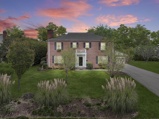 9 Pine Hill Avenue Ext, Norwalk, CT 06855 - view of front of home featuring a chimney, concrete driveway, a yard, and brick siding
