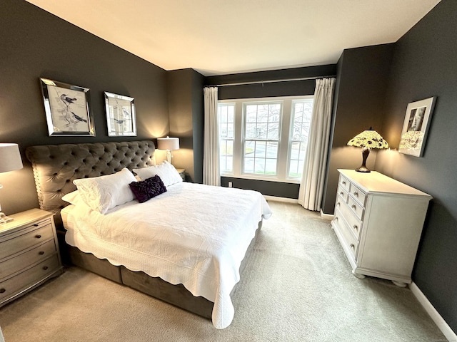 bedroom featuring baseboards and light colored carpet