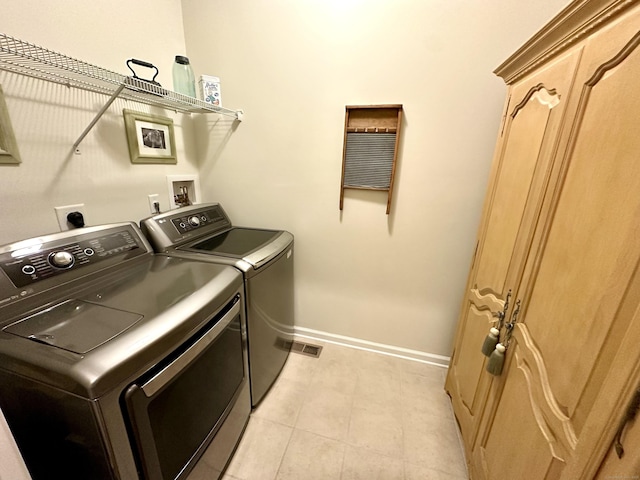 washroom featuring light tile patterned floors, baseboards, laundry area, and independent washer and dryer