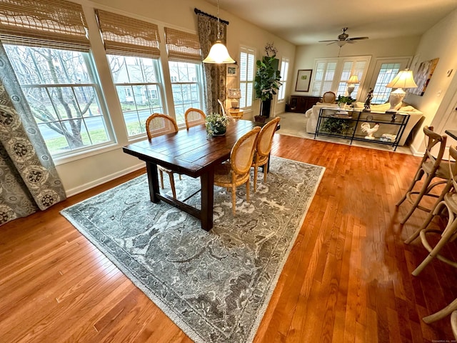 dining area featuring baseboards, wood finished floors, and ceiling fan