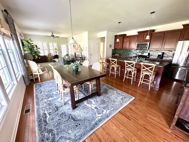 dining area featuring visible vents, dark wood-type flooring, and ceiling fan