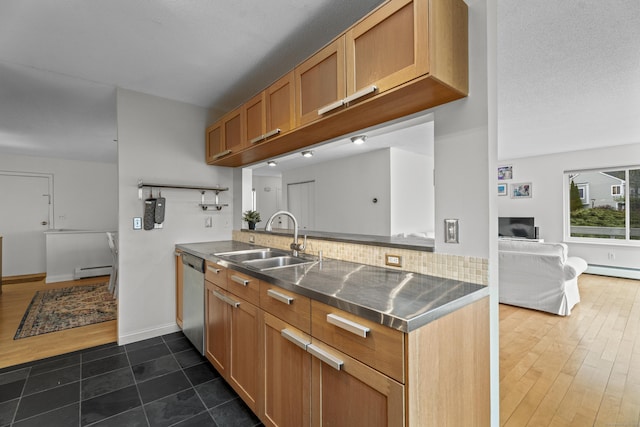 kitchen with a baseboard heating unit, stainless steel countertops, a peninsula, stainless steel dishwasher, and a sink