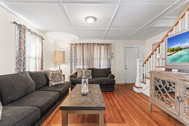 living room with baseboards, a wealth of natural light, wood finished floors, and stairway