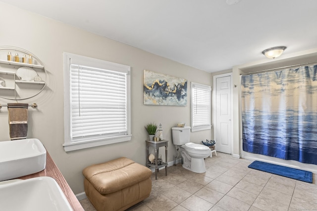 bathroom with baseboards, toilet, tile patterned flooring, and curtained shower